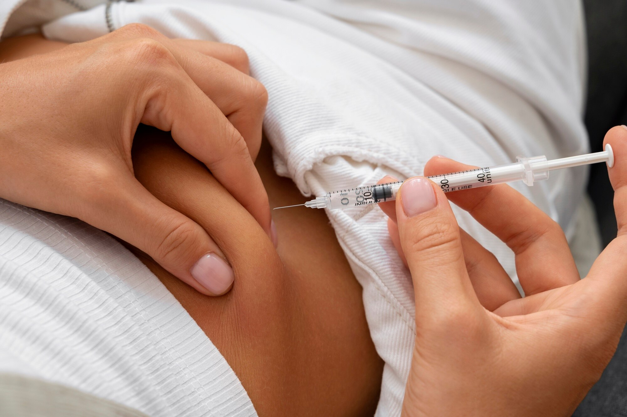 High angle woman injecting insulin at home